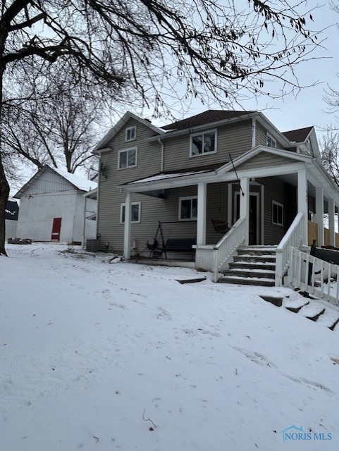 snow covered property with a porch