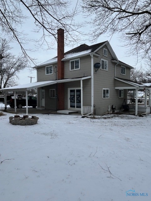 snow covered property featuring an outdoor fire pit