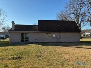 rear view of property featuring a lawn