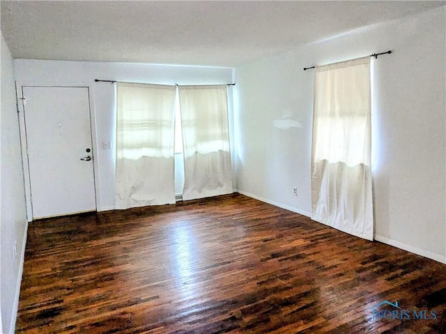 spare room featuring dark wood-type flooring