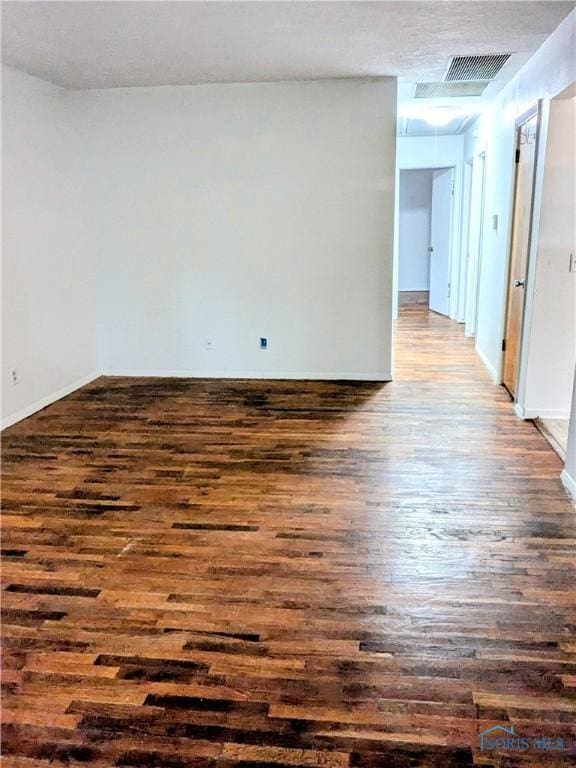 spare room with dark wood-type flooring