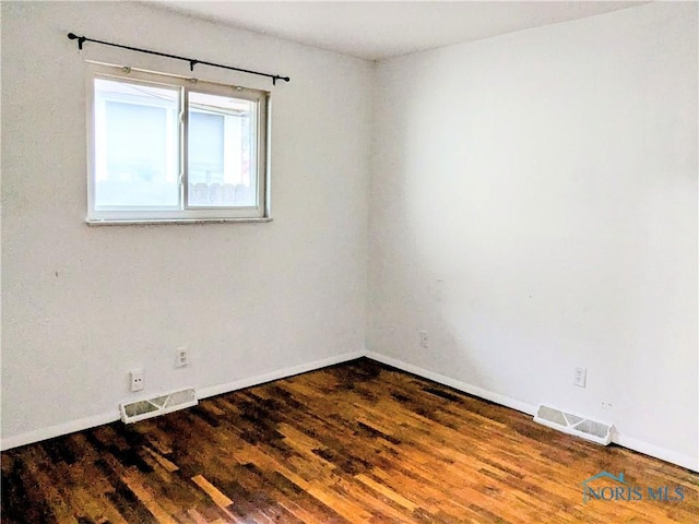 empty room with dark hardwood / wood-style flooring