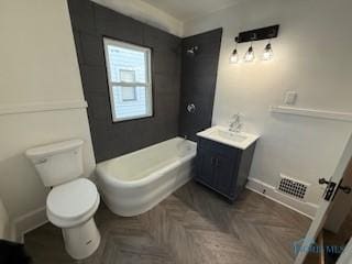 bathroom featuring parquet flooring, vanity, and toilet