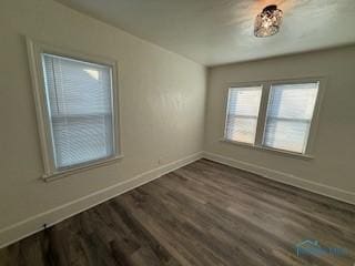 empty room with dark hardwood / wood-style flooring