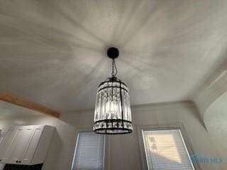 interior details with beam ceiling and an inviting chandelier