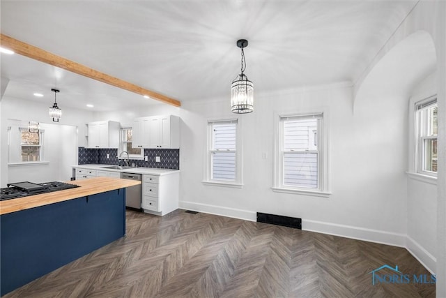 kitchen with butcher block counters, sink, white cabinetry, decorative light fixtures, and dishwasher