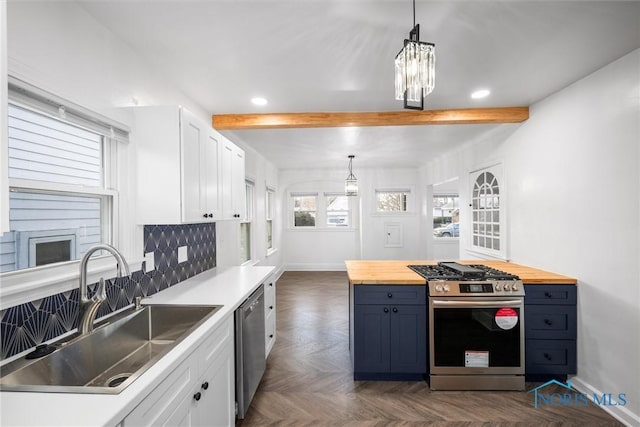 kitchen featuring white cabinetry, sink, butcher block countertops, and appliances with stainless steel finishes