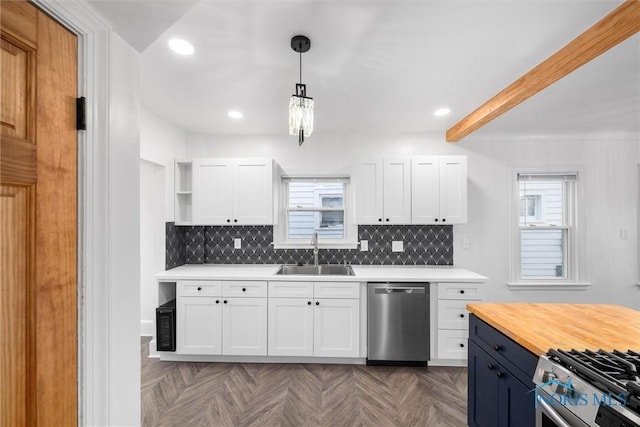 kitchen featuring appliances with stainless steel finishes, a wealth of natural light, pendant lighting, sink, and white cabinets