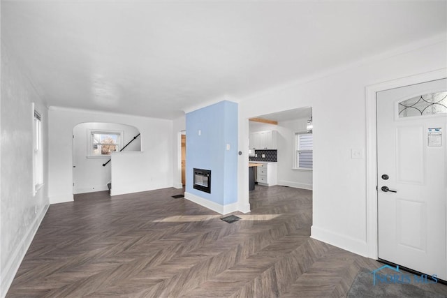 unfurnished living room featuring dark parquet floors