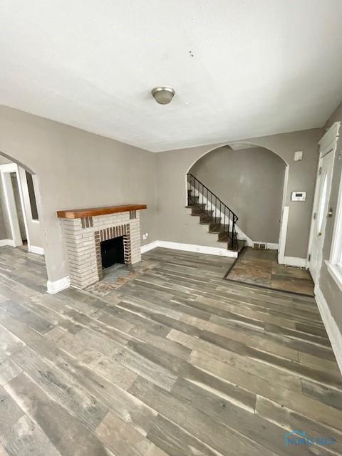 unfurnished living room with a fireplace and dark hardwood / wood-style floors