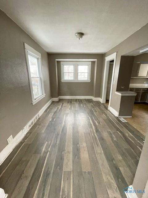 unfurnished room with dark wood-type flooring