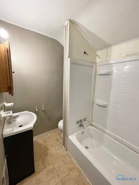 full bathroom featuring a textured ceiling, vanity, tiled shower / bath combo, tile patterned flooring, and toilet