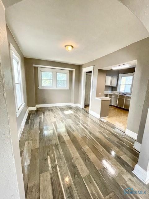 unfurnished living room featuring dark hardwood / wood-style flooring and a wealth of natural light