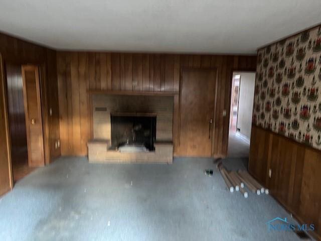 unfurnished living room featuring wooden walls