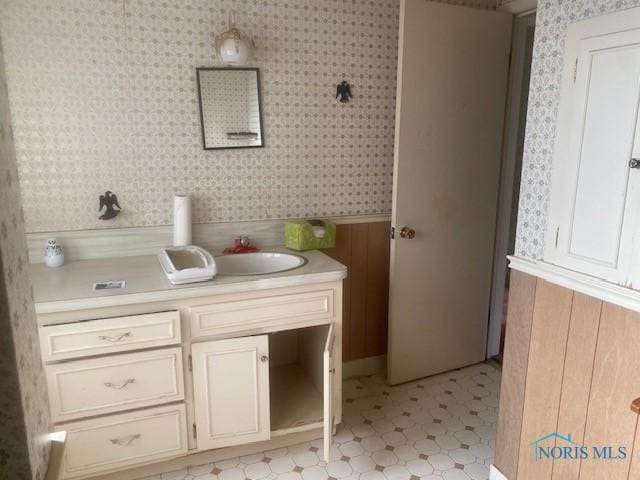 bathroom with vanity and wooden walls