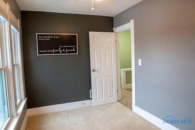 unfurnished room featuring light carpet