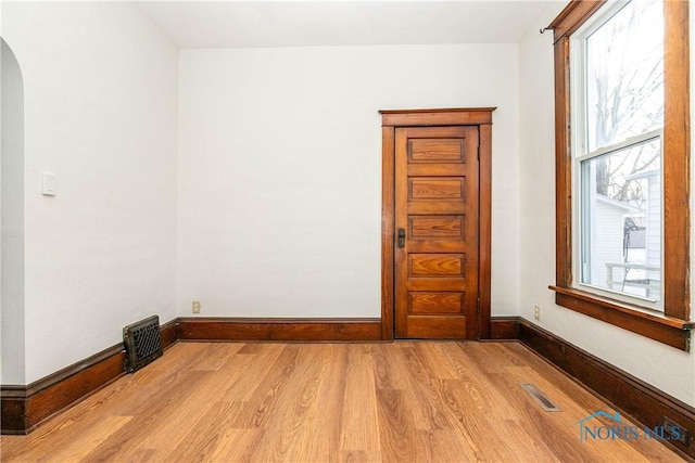 spare room featuring light hardwood / wood-style floors and a healthy amount of sunlight