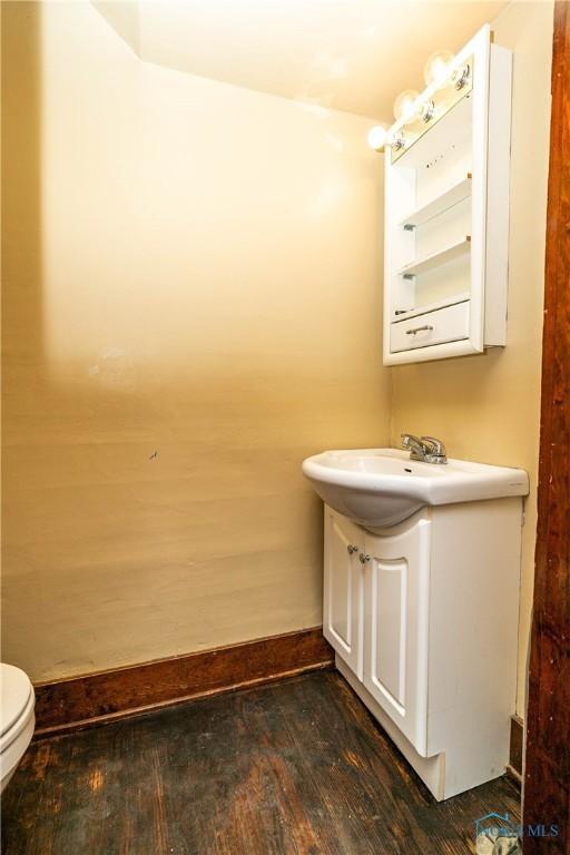 bathroom with hardwood / wood-style floors, vanity, and toilet