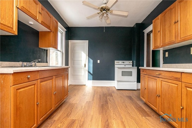 kitchen with white electric range oven, light wood-type flooring, ceiling fan, and sink