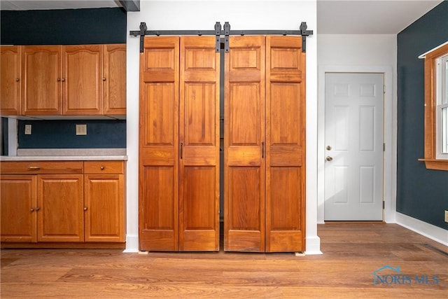 kitchen with a barn door and light hardwood / wood-style flooring