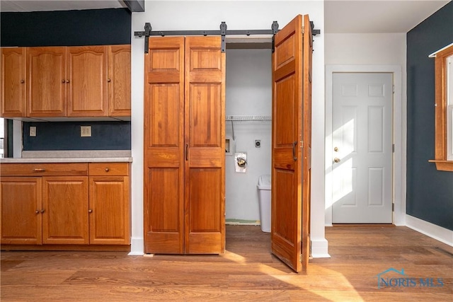 kitchen with a barn door and light hardwood / wood-style floors