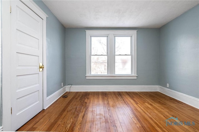 unfurnished room featuring hardwood / wood-style floors and a textured ceiling