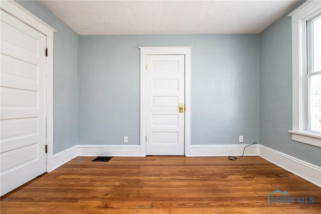 empty room featuring hardwood / wood-style floors and a textured ceiling