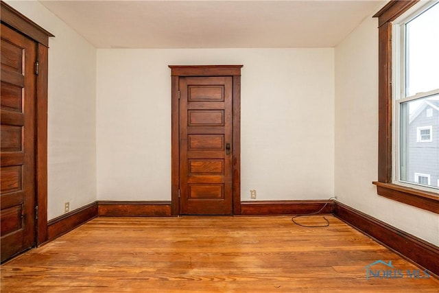 unfurnished room with light wood-type flooring and a healthy amount of sunlight