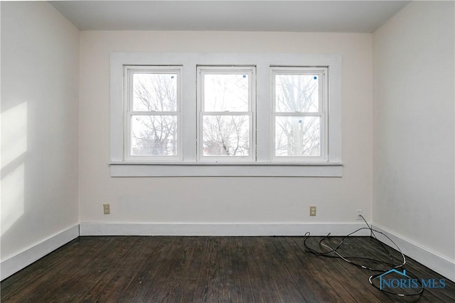 spare room with dark hardwood / wood-style floors and a wealth of natural light