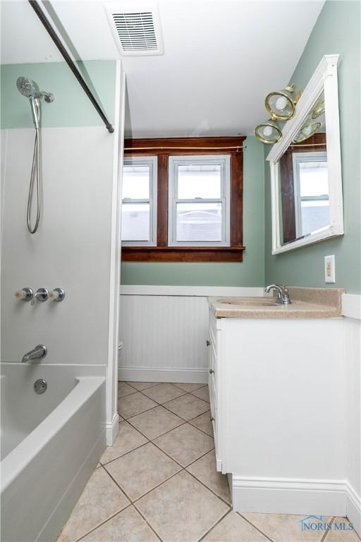 bathroom featuring tile patterned floors, vanity, and shower / tub combination