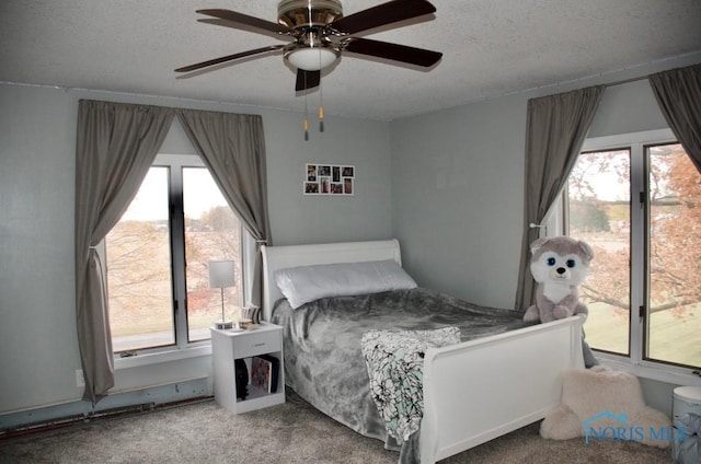 bedroom featuring ceiling fan, carpet, and a textured ceiling