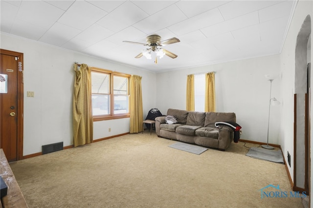 carpeted living room with ceiling fan and ornamental molding