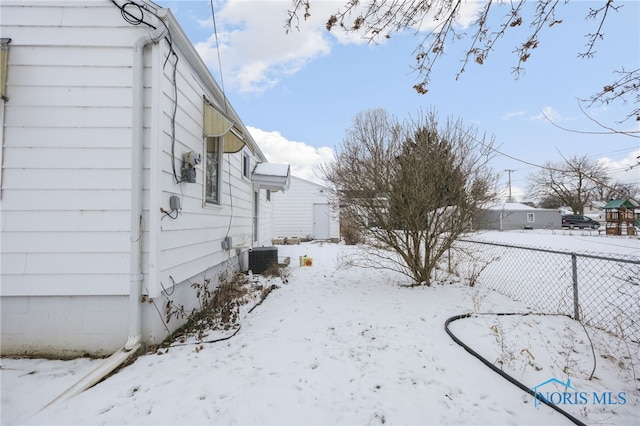 yard layered in snow with central air condition unit