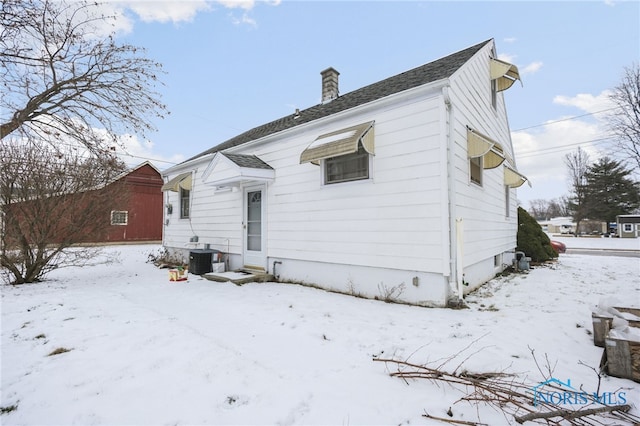 snow covered rear of property with central AC