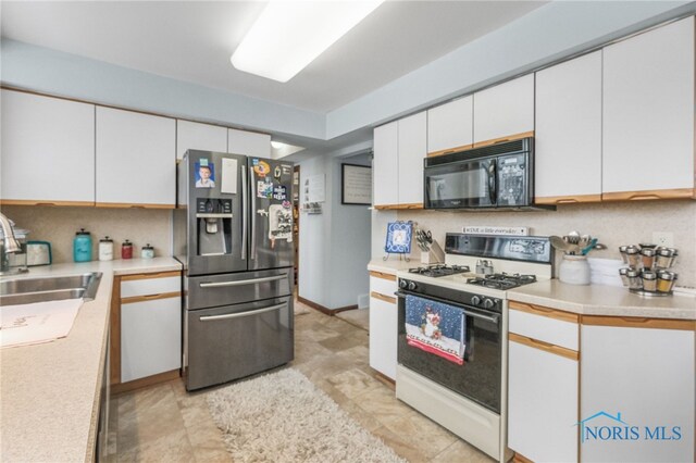 kitchen with sink, white range with gas stovetop, white cabinets, and stainless steel fridge with ice dispenser