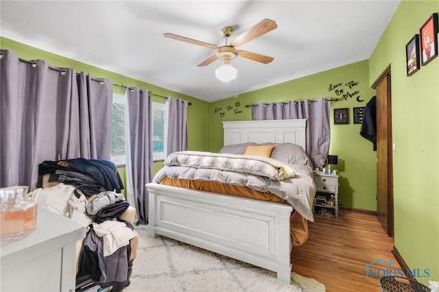 bedroom with ceiling fan, lofted ceiling, and light hardwood / wood-style floors