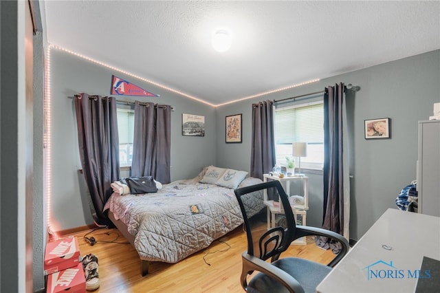 bedroom with wood-type flooring and lofted ceiling