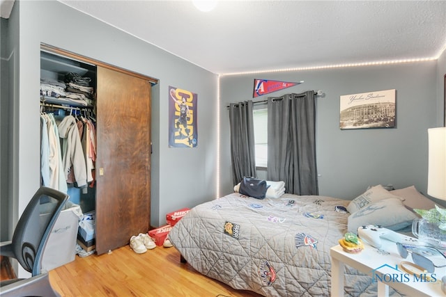 bedroom with wood-type flooring and a closet