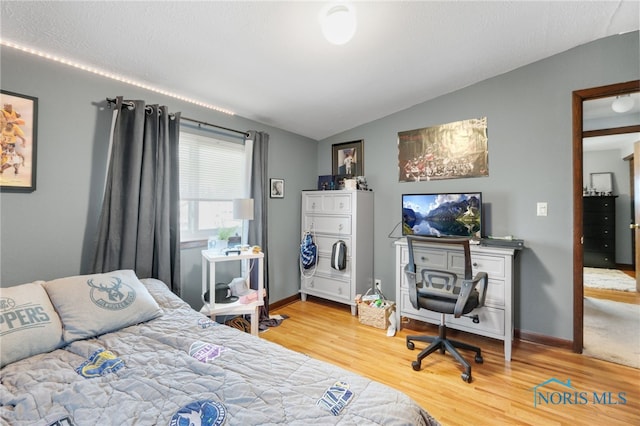 bedroom with hardwood / wood-style flooring and lofted ceiling