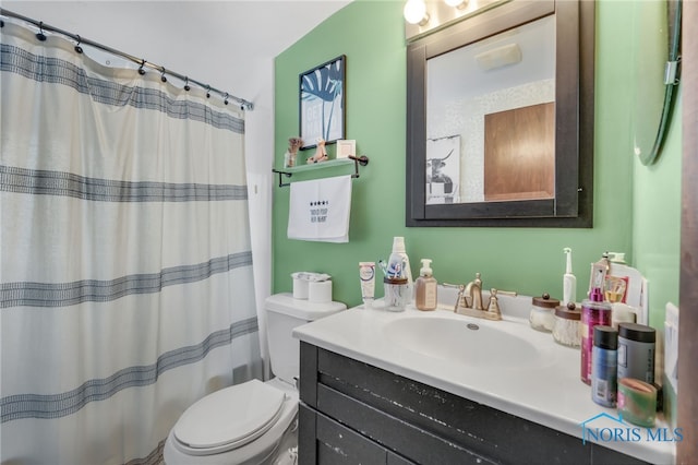 bathroom featuring vanity, a shower with shower curtain, and toilet