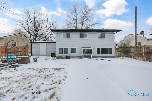 snow covered property featuring central air condition unit