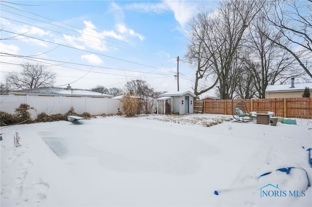 yard covered in snow with a shed