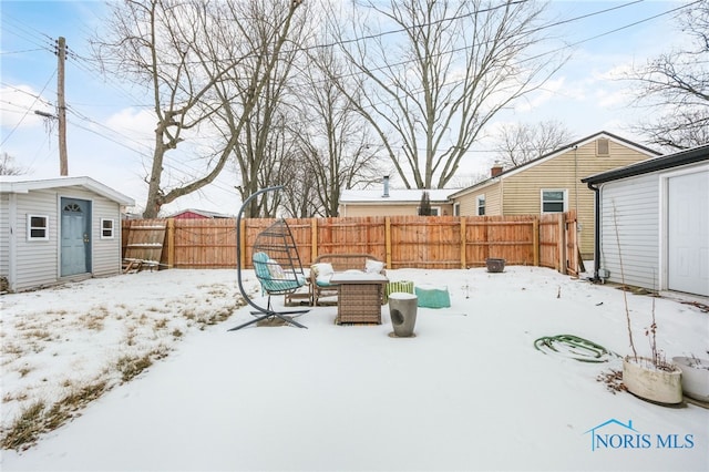 yard layered in snow with an outdoor structure