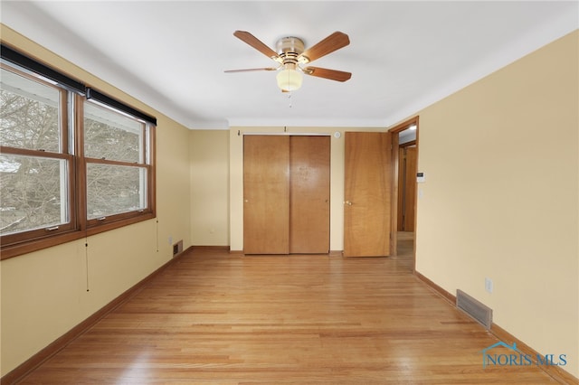 unfurnished bedroom featuring light wood-type flooring and ceiling fan