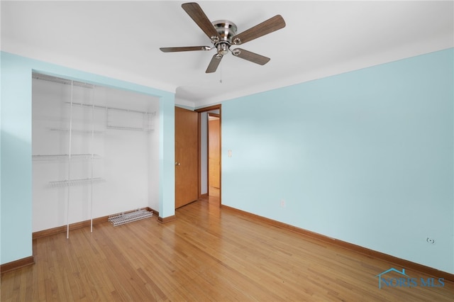 unfurnished bedroom featuring ceiling fan, light wood-type flooring, and a closet