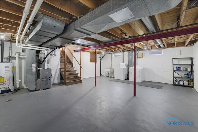 basement featuring heating unit, sink, water heater, separate washer and dryer, and electric panel