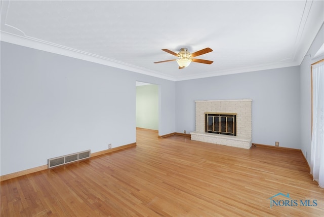 unfurnished living room featuring light hardwood / wood-style floors, a brick fireplace, ceiling fan, and ornamental molding