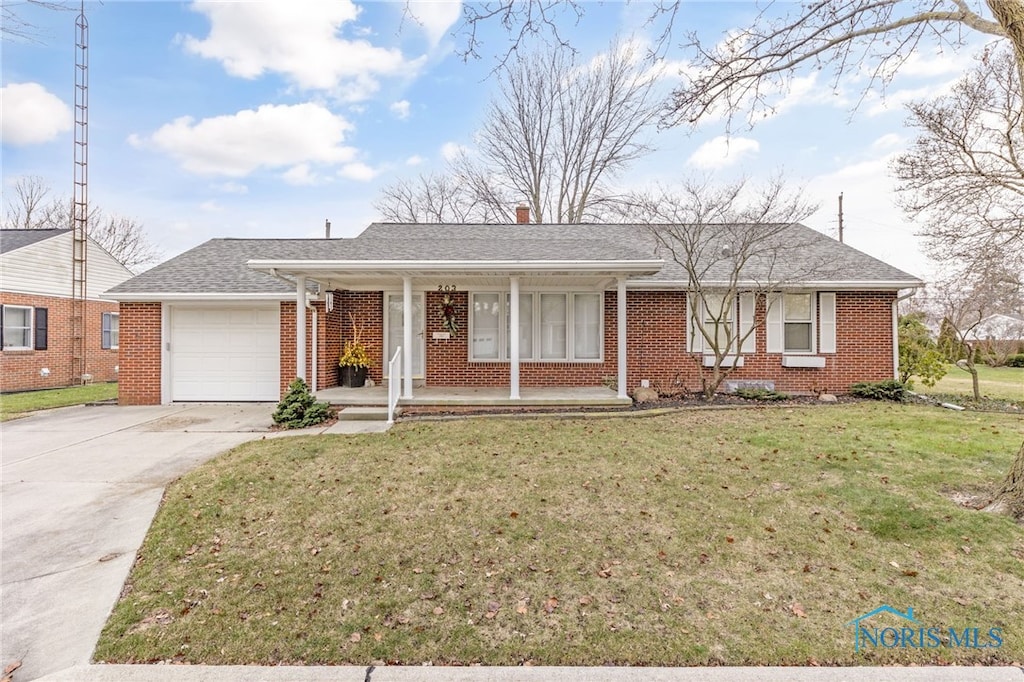 single story home featuring covered porch, a garage, and a front yard