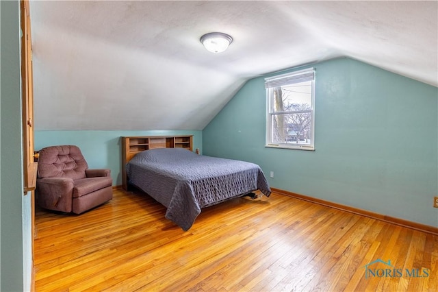 bedroom with light hardwood / wood-style floors and lofted ceiling