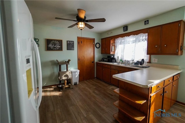 kitchen featuring ceiling fan, white fridge, kitchen peninsula, and dark wood-type flooring